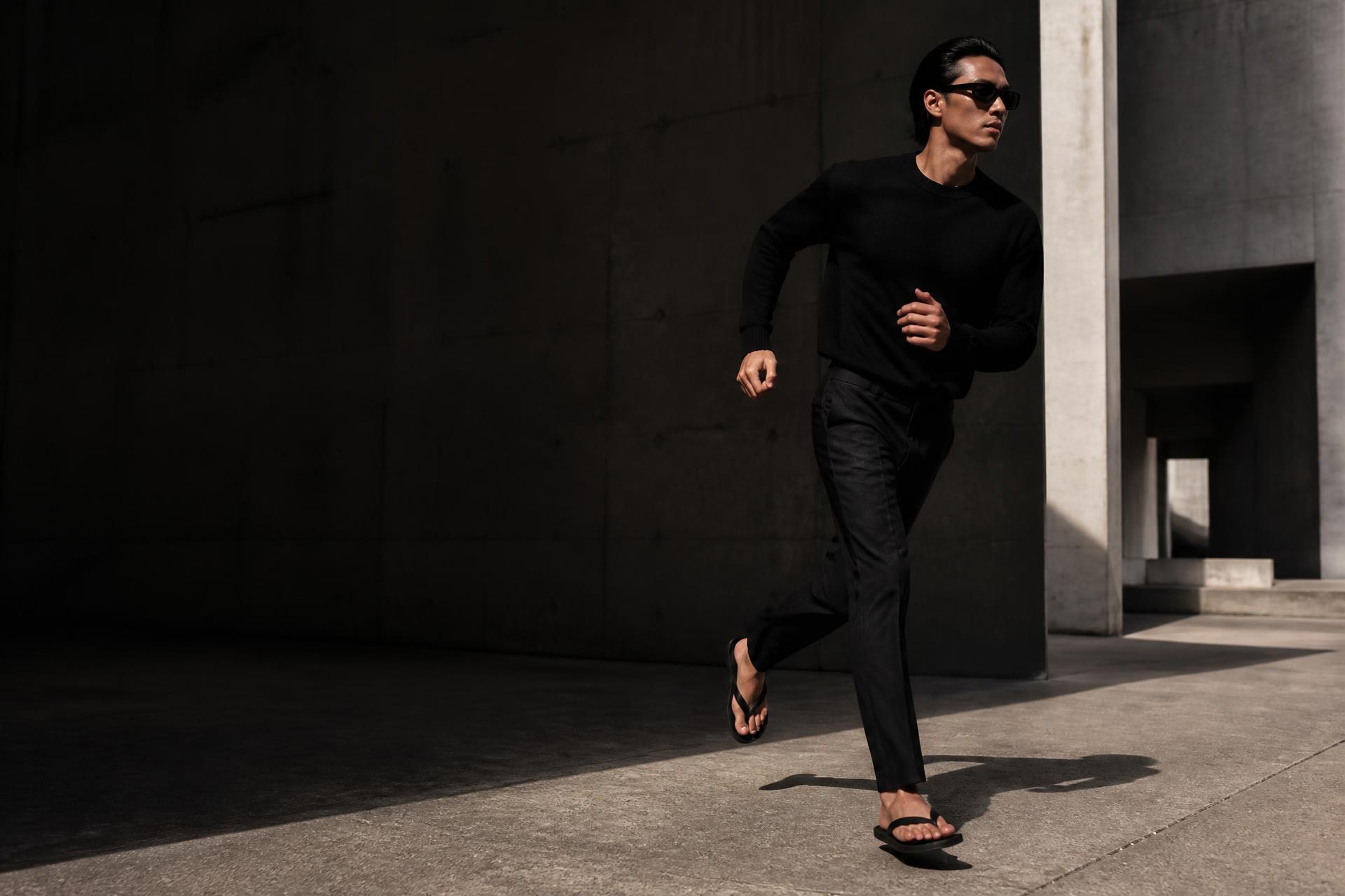 Operative moving through brutalist architecture in FLOPMAXING gear
